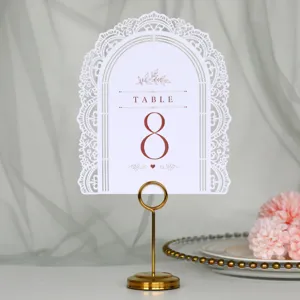Elegante carta per numeri da tavolo di nozze bianca traforata con supporto dorato.