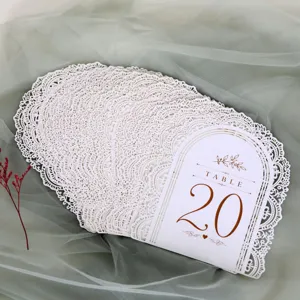 Dettaglio di segnaposto matrimonio bianco intagliato al laser, design ad arco traforato.