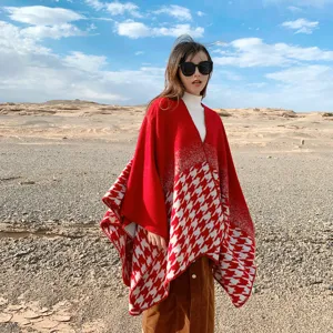 Detail shot of women's red houndstooth knit cape shawl, stylish winter warm outdoor poncho.