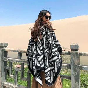 Detail view of a black and white geometric patterned winter poncho shawl for women outdoor travel