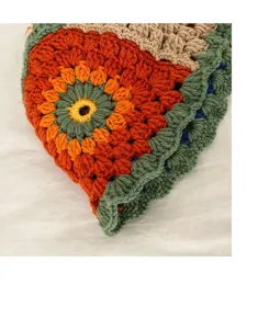 Nahaufnahme eines bunten, handgefertigten Häkelblumen-Eimerhuts mit weicher Stricktextur.