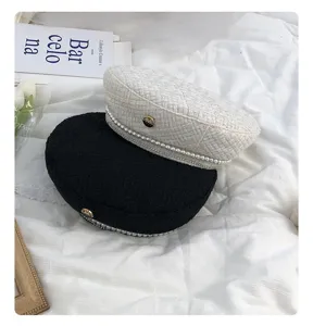 Primo piano dettagliato di eleganti berretti in tweed con finiture di perle e strass per donne.