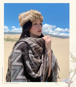 Bohemian winter warm cashmere-like cape and chic faux fur hat detail shot, travel fashion.