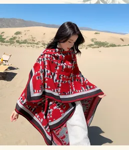 Detailansicht des stilvollen Winter Strick Umhang Schals mit auffälligem rot schwarzem Muster.