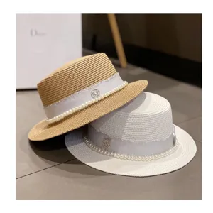 Detailed view of elegant women straw hat with pearl ribbon decoration in summer.