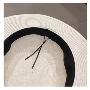 White straw sun hat interior detail, featuring a black sweatband and adjustable inner drawstring.