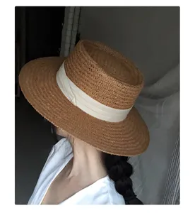 Chapeau de paille plat élégant avec large ruban, idéal pour la plage en été et les sorties au soleil.