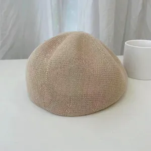 Nahaufnahme der leichten atmungsaktiven Strickbarette in Beige mit feiner Textur.