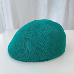 Detailaufnahme des leichten atmungsaktiven grünen Strickbérets mit feiner Struktur.