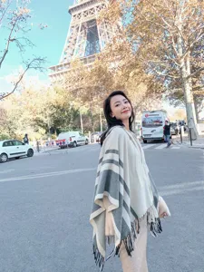 Detailed shot of women hooded fringe poncho in beige and grey stripe, cozy autumn winter wear.