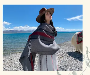 Outdoor scenic detail view of bohemian tassel wool-feel cape shawl, perfect travel wrap.