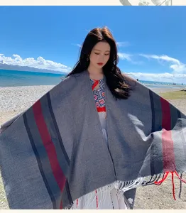 Detailed view of grey cozy cashmere-feel cape shawl outdoors by lake, thick warm winter wear.