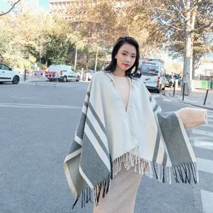 Detailed shot of the winter hooded striped cape with chic tassels, cozy warmth and elegant style.