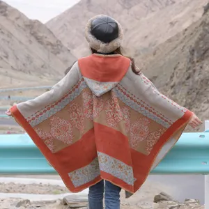 Ethnic style knitted hooded cape detail showing geometric patterns and fringe design.