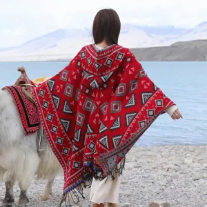 Detail view of women's ethnic style knitted hooded poncho cape with fringe and geometric patterns.