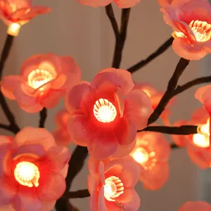 LED kersenbloesem boom licht detail, roze bloemen takken met warme gloeiende lichten.