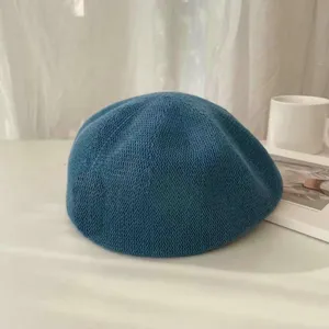 Detailaufnahme der blauen Strickbarette mit atmungsaktiver Textur und feiner Handwerkskunst.