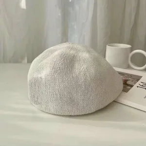 Detailaufnahme einer hellgrauen Strickbarette, atmungsaktive Frühlings- und Sommermütze.