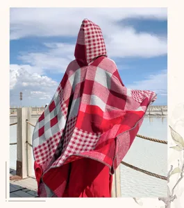 Red and white plaid hooded cape detail view, cozy winter travel poncho cloak outdoor style.