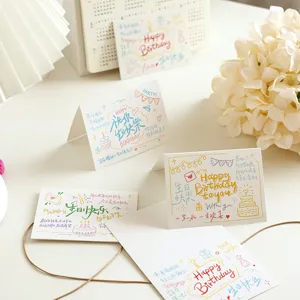 Hand-lettered birthday greeting card detail, gold foil blessing design, bakery flower shop card.