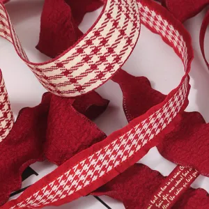 Detailed view of burgundy houndstooth ribbon and textured red fabric for DIY craft