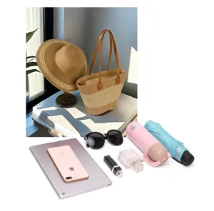 Borsa tote in paglia intrecciata a mano e cappello con oggetti da viaggio per le vacanze.