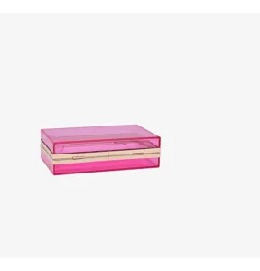 Close-up detail of a pink transparent acrylic evening clutch bag with gold frame.