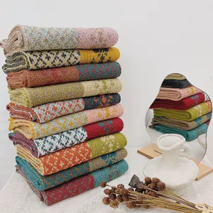 Dettaglio sciarpa lavorata a maglia per bambini, motivi floreali colorati e blocchi geometrici