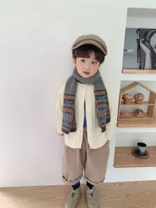 Vista dettagliata di sciarpa in maglia per bambini e cardigan accogliente con motivi colorati.