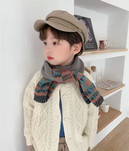 Primo piano dettagliato di sciarpa in maglia per bambini e cardigan, look invernale.