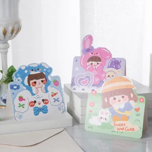Vista detallada de lindas tarjetas de felicitación de chicas de dibujos animados y sobres.