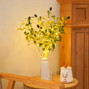 Artificial olive branch with LED string lights in white ceramic vase for home decor