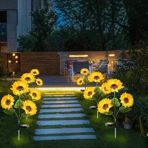 Outdoor solar sunflower garden light detail showing warm glowing flower heads and solar panel.