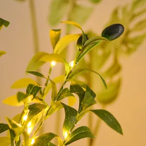Detailed close-up of artificial olive leaves with warm LED fairy lights for home and hotel decor.