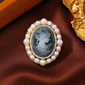 Vintage oval cameo brooch featuring pearl rim and rhinestone accents for chic coat decoration.