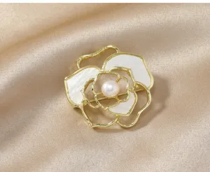 Elegant gold camellia flower brooch with pearl and white petal inlay for coat accessories.