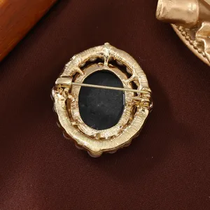 Vintage oval pearl cameo brooch back detail, elegant gold metal filigree pin accessory.