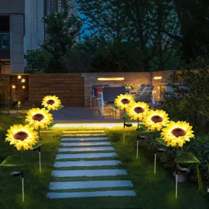 Outdoor solar sunflower garden light detail showing glowing flower lamps on lawn path.