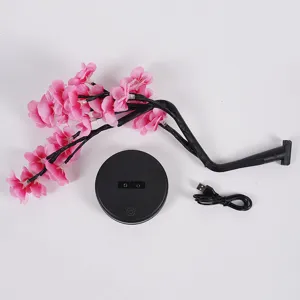 Gedetailleerd overzicht van LED kersenbloesem boom lamp onderdelen, roze takken en basis.
