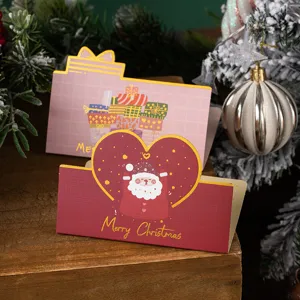 Gedetailleerde close-up van kerstvouwkaarten met schattige kerstman en cadeautjes.