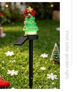 Vue détaillée de la lampe solaire de jardin de Noël avec base LED lumineuse et décorations.