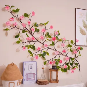 Nahaufnahme der künstlichen Kirschblüten-Zweig-LED-Lichterkette an einer warmen Zimmerwand.
