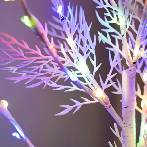 Dettaglio in primo piano di rami di betulla bianca con luci LED colorate per la camera.