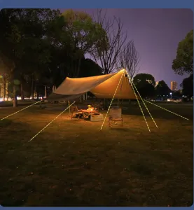 Vista detallada de la iluminación brillante de cuerdas de tienda en un campamento nocturno.