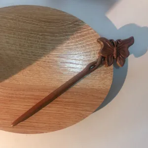 Hölzerner Schmetterling Haarnadel Detail, eleganter antiker Haarstab für traditionelle Frisure.