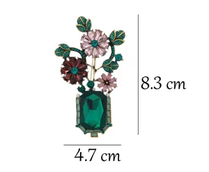 Detailed close-up of the vintage green crystal flower vase brooch featuring sparkling rhinestones.