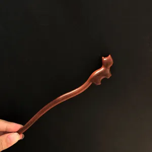 Vue detaillee d'une epingle a cheveux creative en bois de santal rouge avec sculpture de chat.