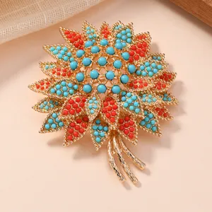 Elegant vintage floral brooch with blue and red beads, gold tone metal fashion accessory for women