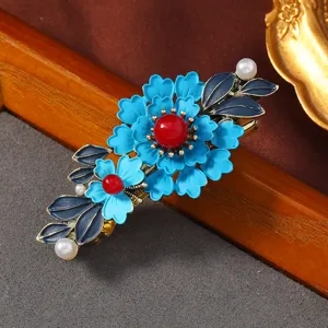 Nahaufnahme Detail der blauen Vintage Blumen Haarklammer mit Perlen und roter Perle.