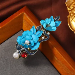 Detailaufnahme der blauen Retro Blumen Haarspange mit Perlen und rotem Schmuckstein.